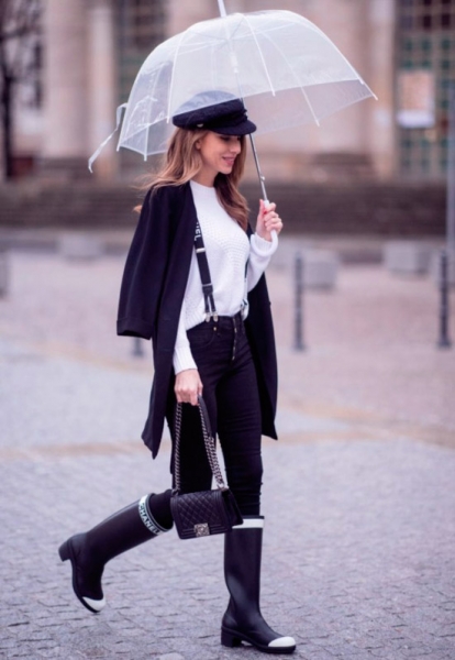 Девушка в черных джинсах скини, белый свитер, черный кардиган, образ дополняют черные резиновые сапоги и небольшая сумочка