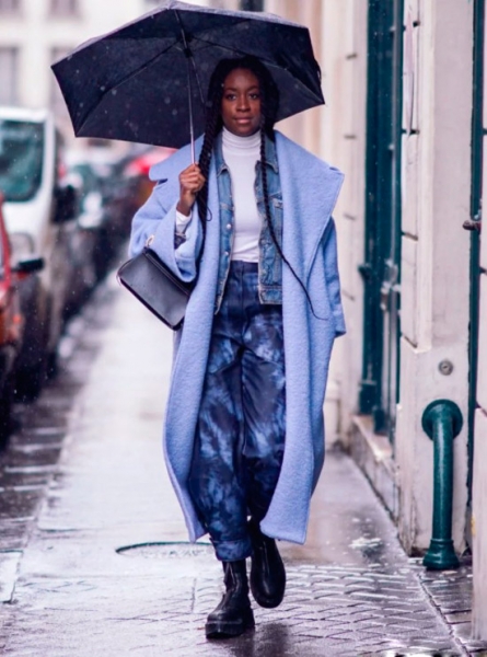Девушка в свободных брюках, джинсовка и длинное голубое пальто тедди, образ дополняют черные ботинки на шнуровке и зонт